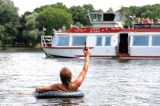 Com cerveja na mão, homem em boia saúda barco em rio na Alemanha