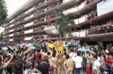 Multidão acompanha desfile de universitários pelados