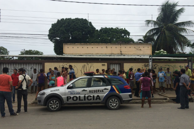 viatura da policia defrente a uma casa com gente