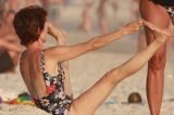 Aos 59, Cássia Kiss mostra flexibilidade e chama atenção ao fazer ioga de maiô na praia