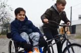 Menino cria bicicleta adaptada para andar com primo cadeirante