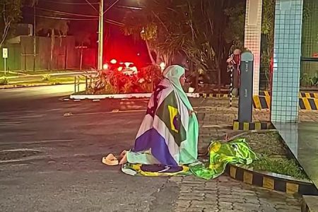 Apoiadora faz oração em frente a condomínio onde ex-presidente cumpre prisão domiciliar